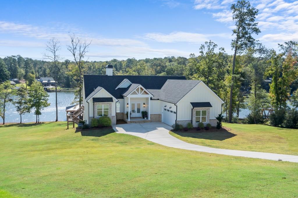 a view of a house with a big yard and large trees