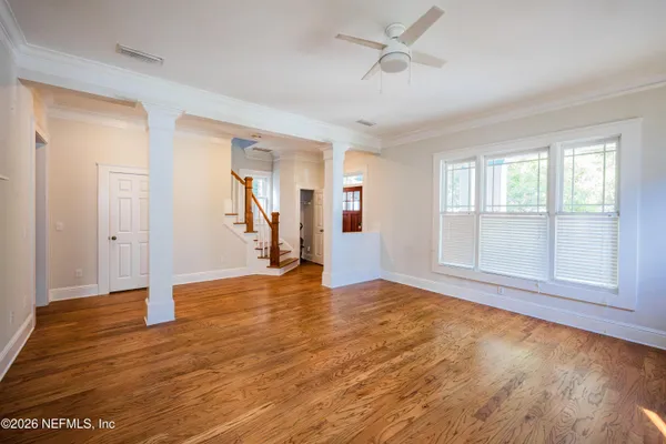 a view of empty room with a fireplace and wooden floor