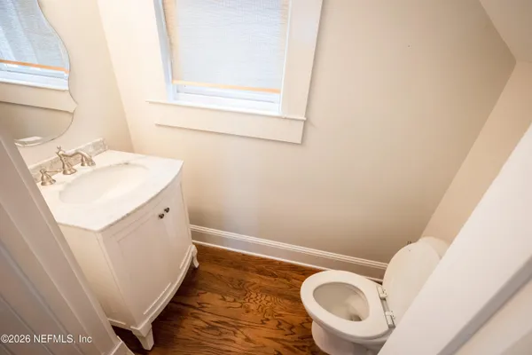 a view of a hallway with wooden floor and staircase