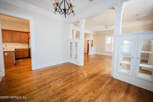 a view of a big room with wooden floor and windows