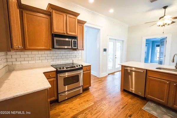 a kitchen with granite countertop a sink a stove and refrigerator