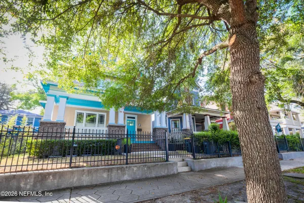 a front view of a house with a tree