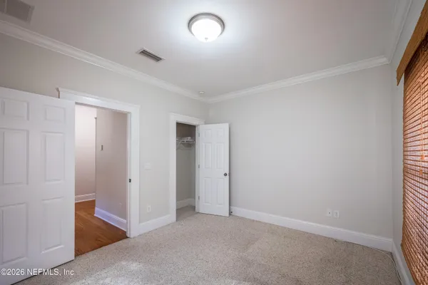 an empty room with closet and a ceiling fan