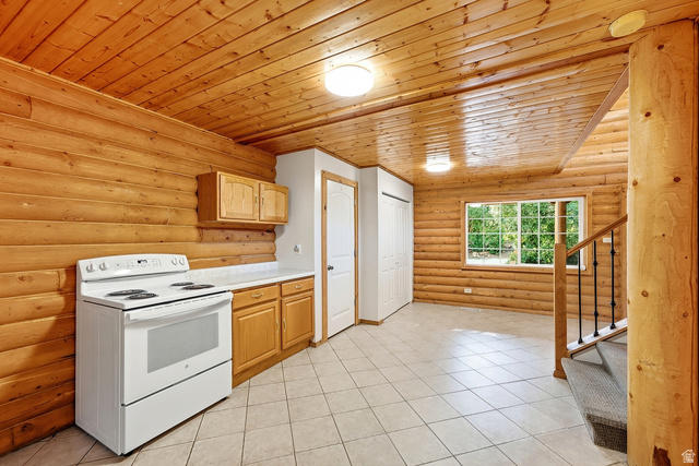 2640 East Weber Canyon Road Oakley, UT 84055 - Photo 15 of 56 Wood plank walls and ceiling, white tile flooring, wood cabinetry, white countertop, and window with exterior exposure