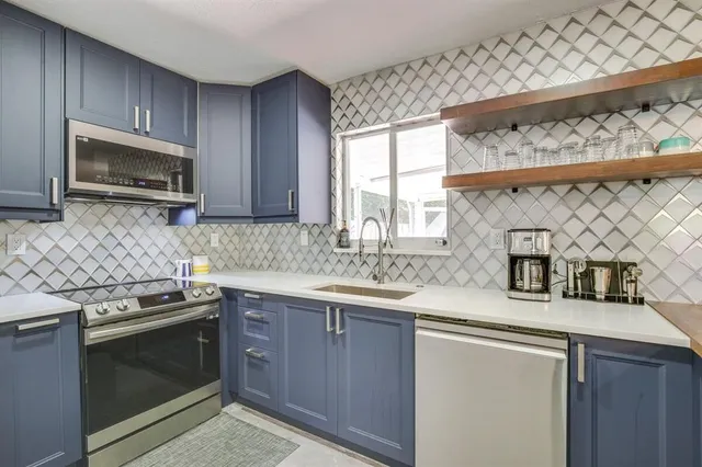 a kitchen with stainless steel appliances a sink stove and microwave