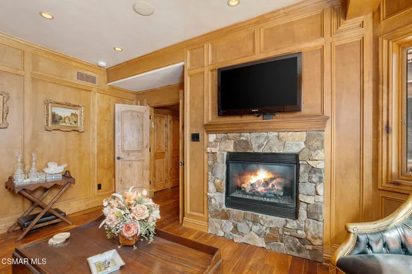 a living room with a fireplace a flat screen tv and a window