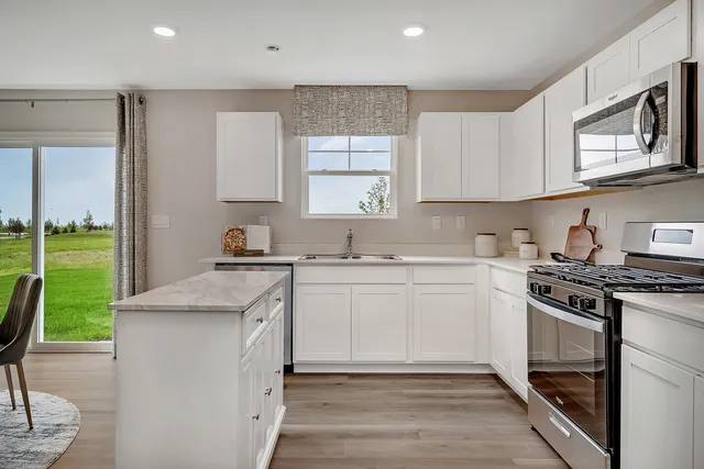 a kitchen with granite countertop white cabinets and white appliances