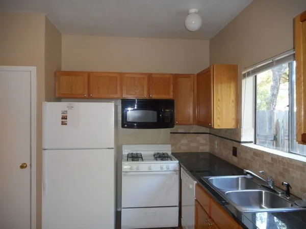 a kitchen with a refrigerator a stove a sink and a cabinets