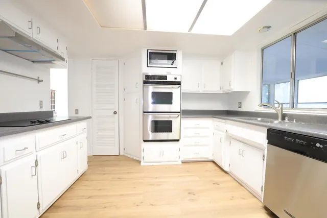 a kitchen with stainless steel appliances kitchen island granite countertop a stove a sink and a microwave