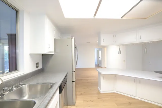 a kitchen with granite countertop white cabinets and white appliances