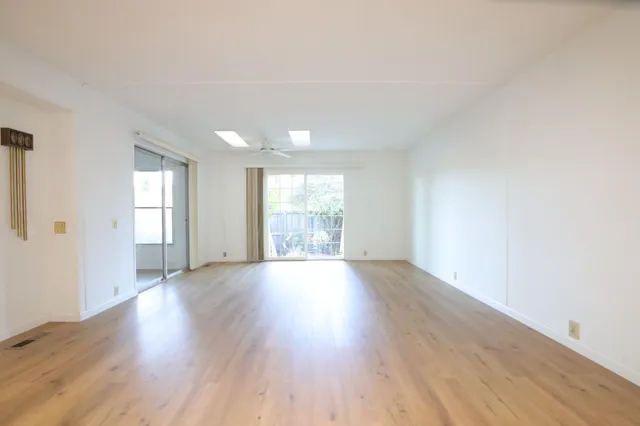 a view of a kitchen and an empty room