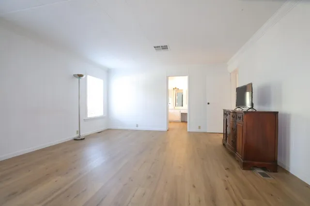a view of empty room with wooden floor and fireplace