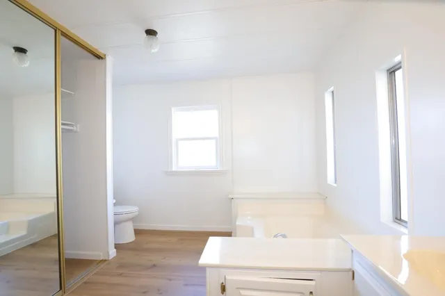 a view of a kitchen with wooden floor and a window