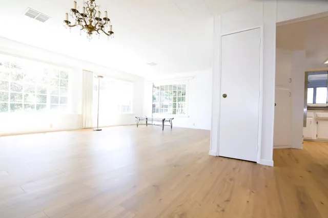 a view of a livingroom with wooden floor and a chandelier