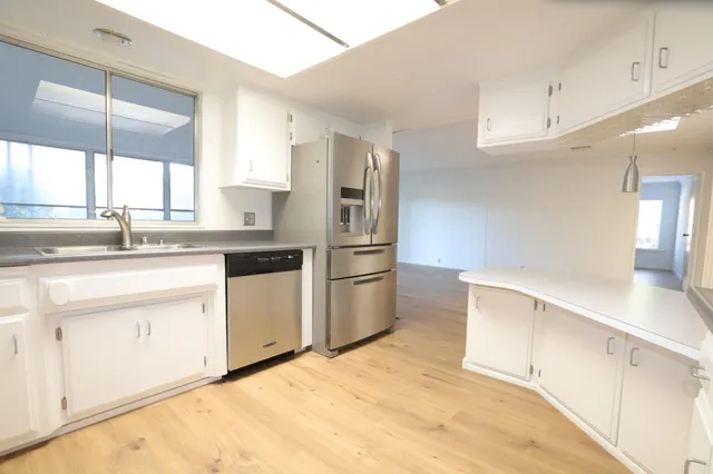 a kitchen with a refrigerator sink and cabinets
