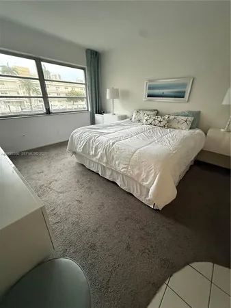 a bedroom with a bed and a large window