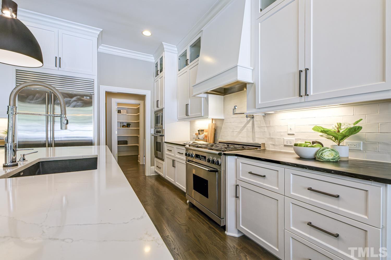 2642 Churchill Road Raleigh, NC 27608 - Photo 30 of 98 a kitchen with granite countertop white cabinets and white appliances