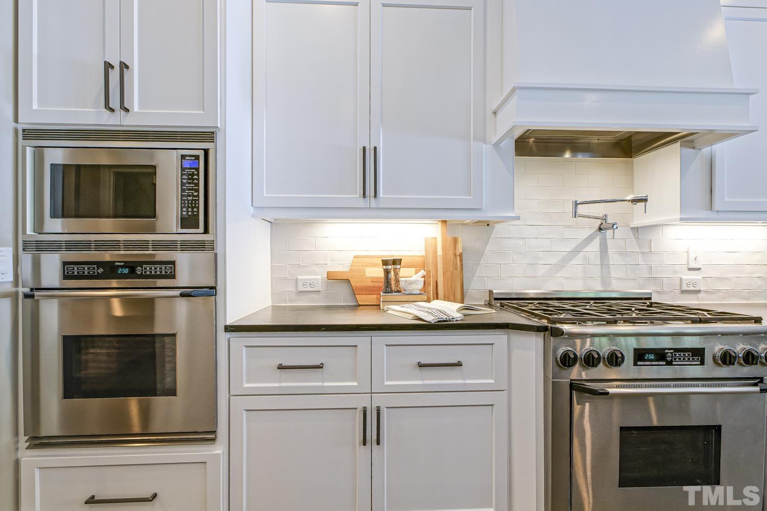 2642 Churchill Road Raleigh, NC 27608 - Photo 31 of 98 a kitchen with granite countertop a stove oven and sink