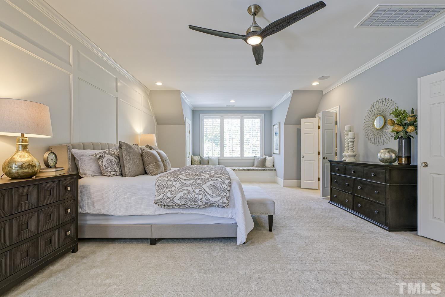 2642 Churchill Road Raleigh, NC 27608 - Photo 50 of 98 a spacious bedroom with a bed and dresser with mirror