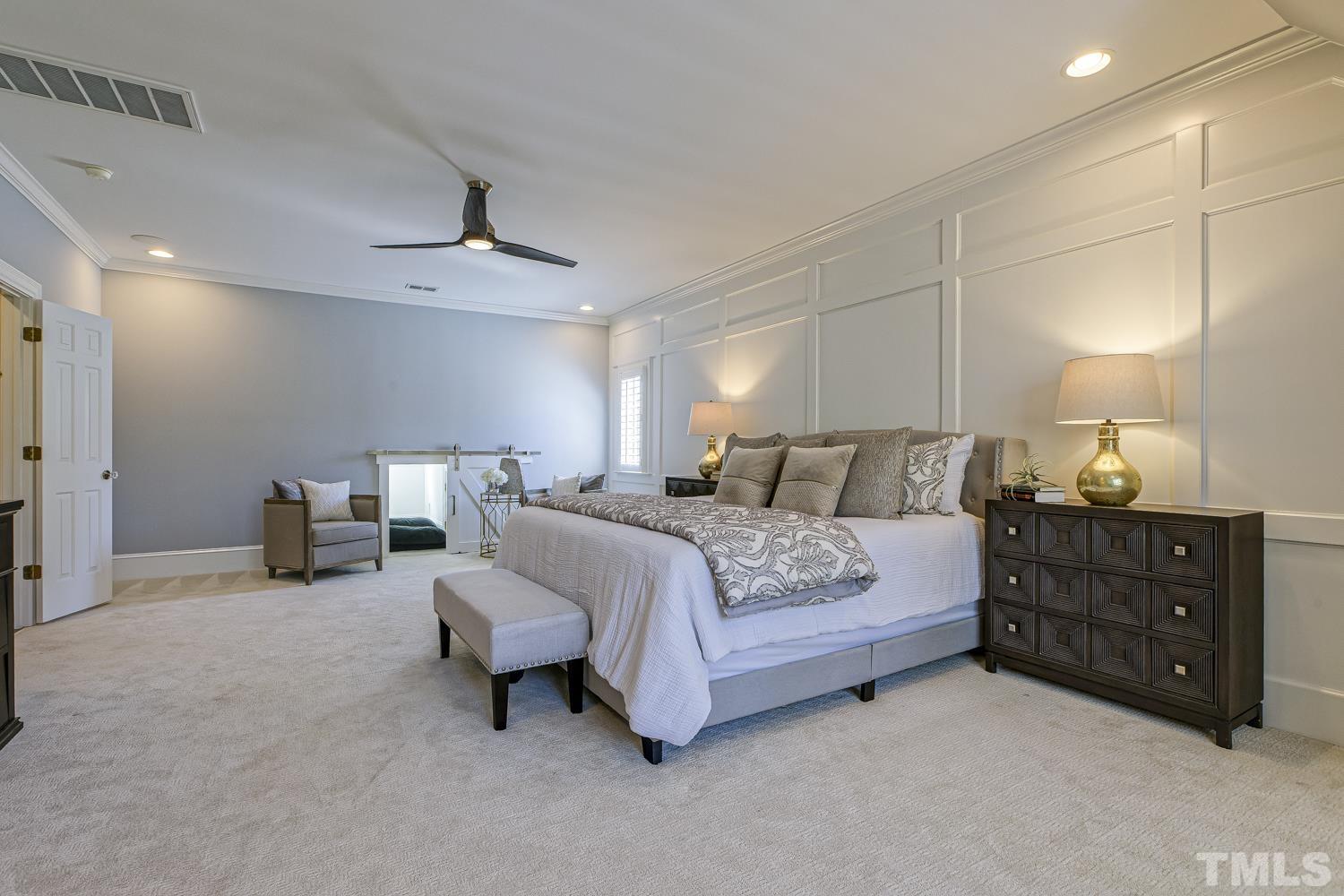 2642 Churchill Road Raleigh, NC 27608 - Photo 51 of 98 a spacious bedroom with a bed a couch and a chandelier