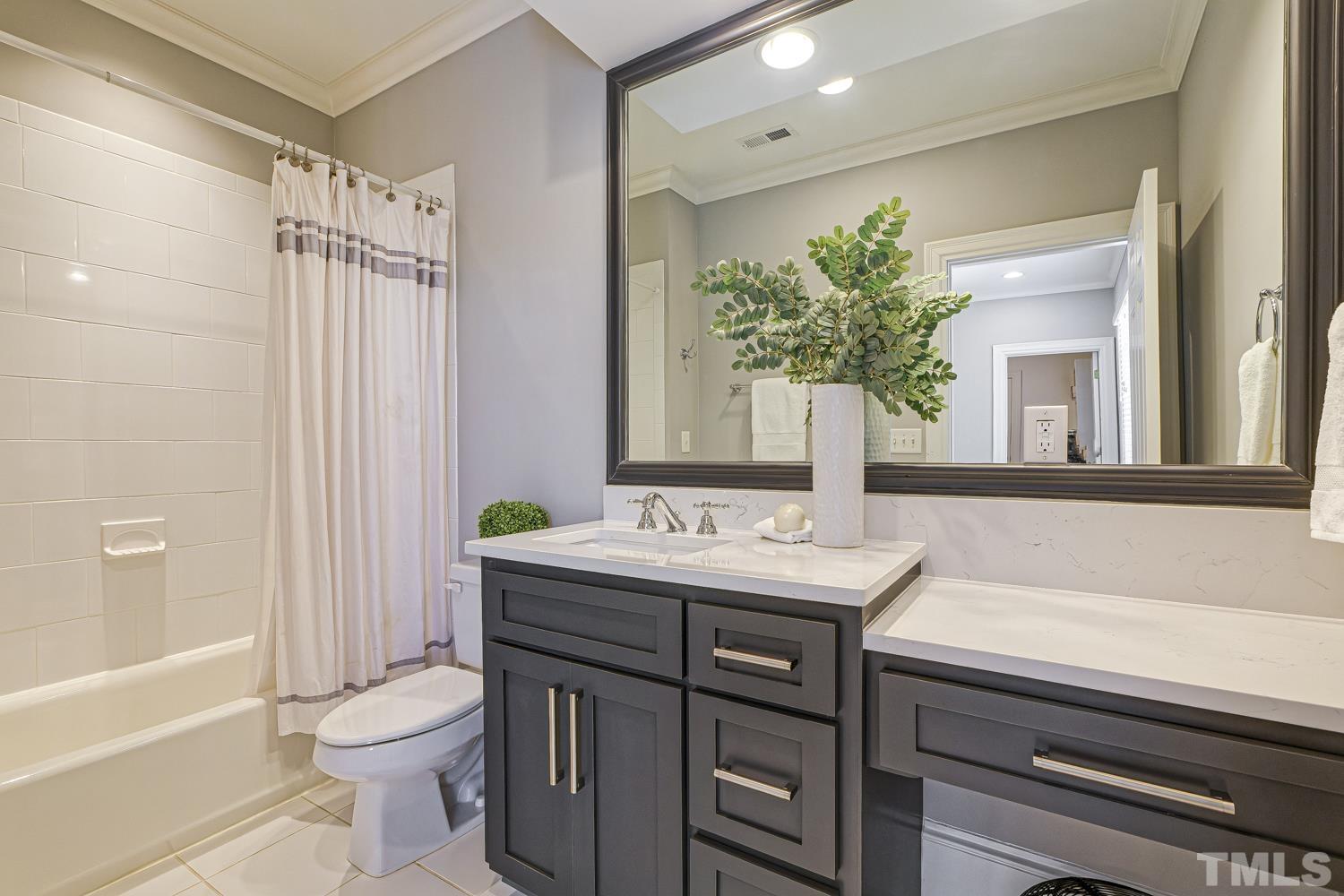 2642 Churchill Road Raleigh, NC 27608 - Photo 70 of 98 a bathroom with a granite countertop sink a toilet a mirror and shower