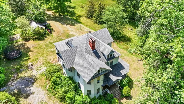 an aerial view of a house with swimming pool and lawn chairs
