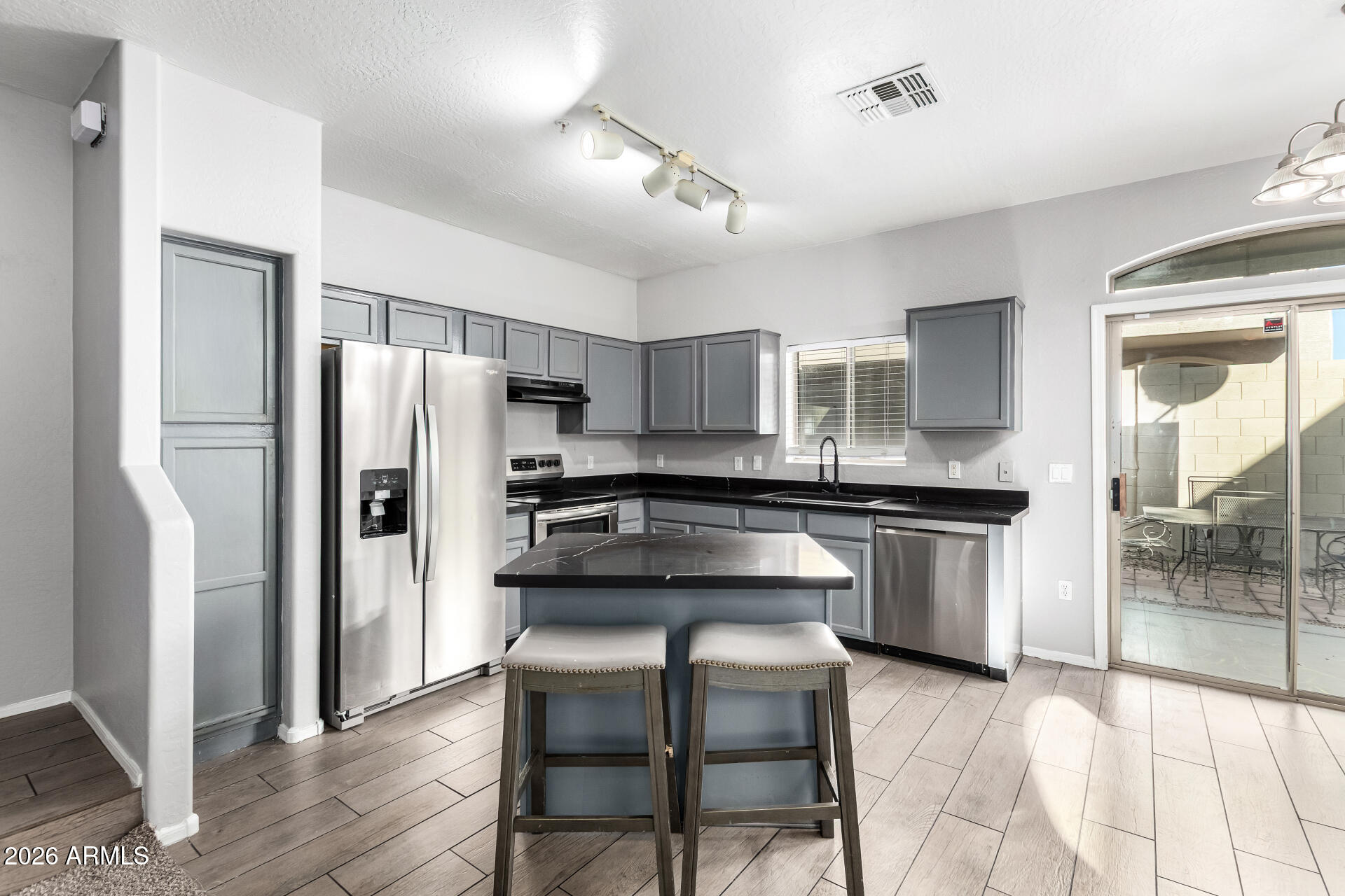 2150 East Bell Road, Unit 1075 Phoenix, AZ 85022 - Photo 12 of 45 a kitchen with a refrigerator a sink and chairs