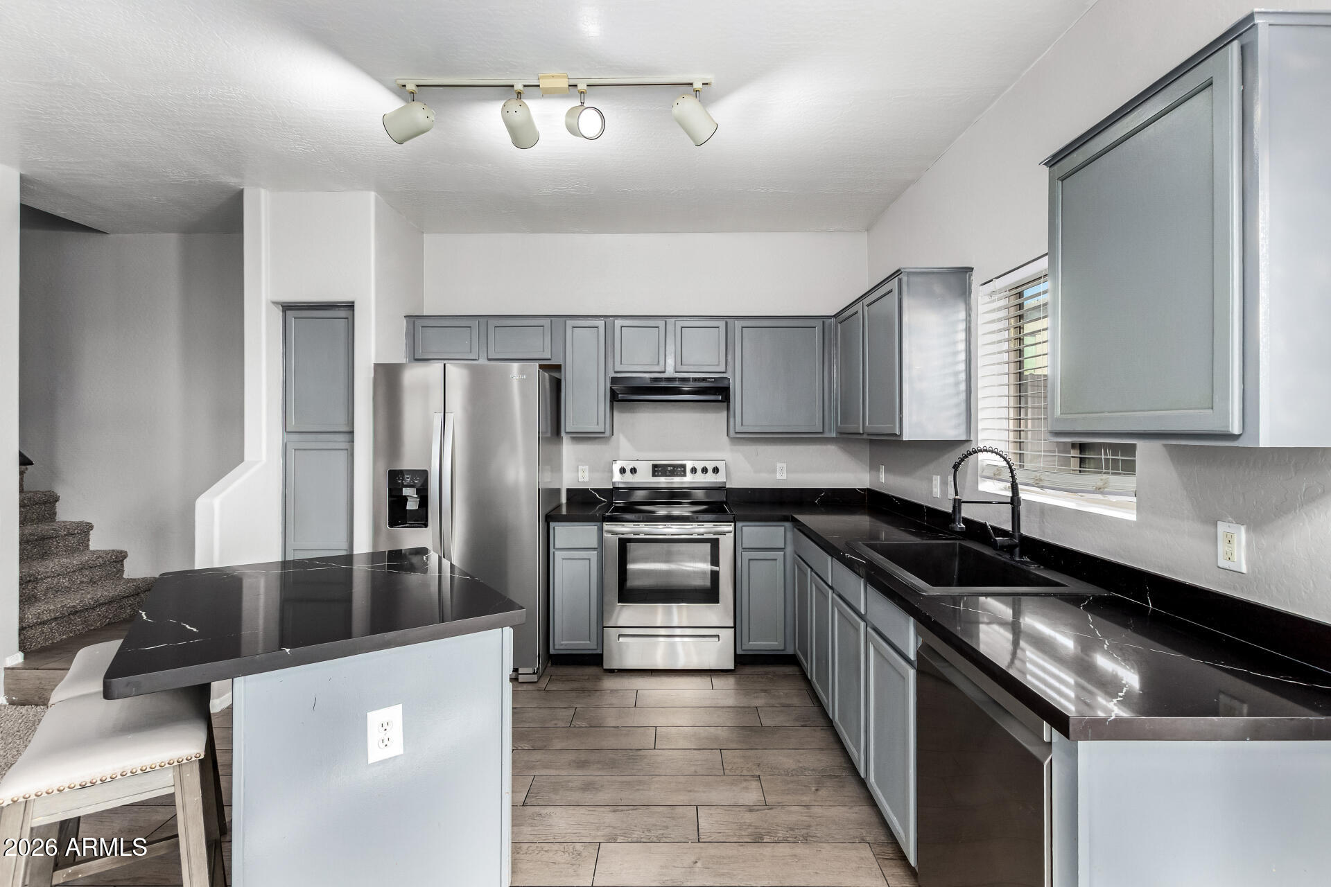 2150 East Bell Road, Unit 1075 Phoenix, AZ 85022 - Photo 13 of 45 a kitchen with stainless steel appliances granite countertop a sink a stove a refrigerator cabinets and a dining table
