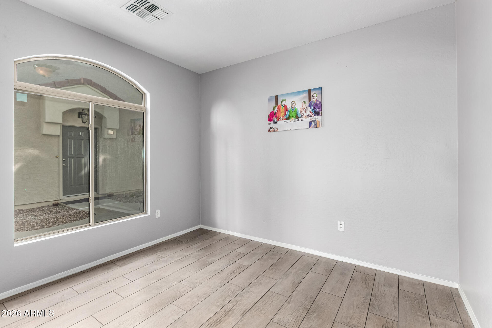 2150 East Bell Road, Unit 1075 Phoenix, AZ 85022 - Photo 31 of 45 an empty room with wooden floor and windows