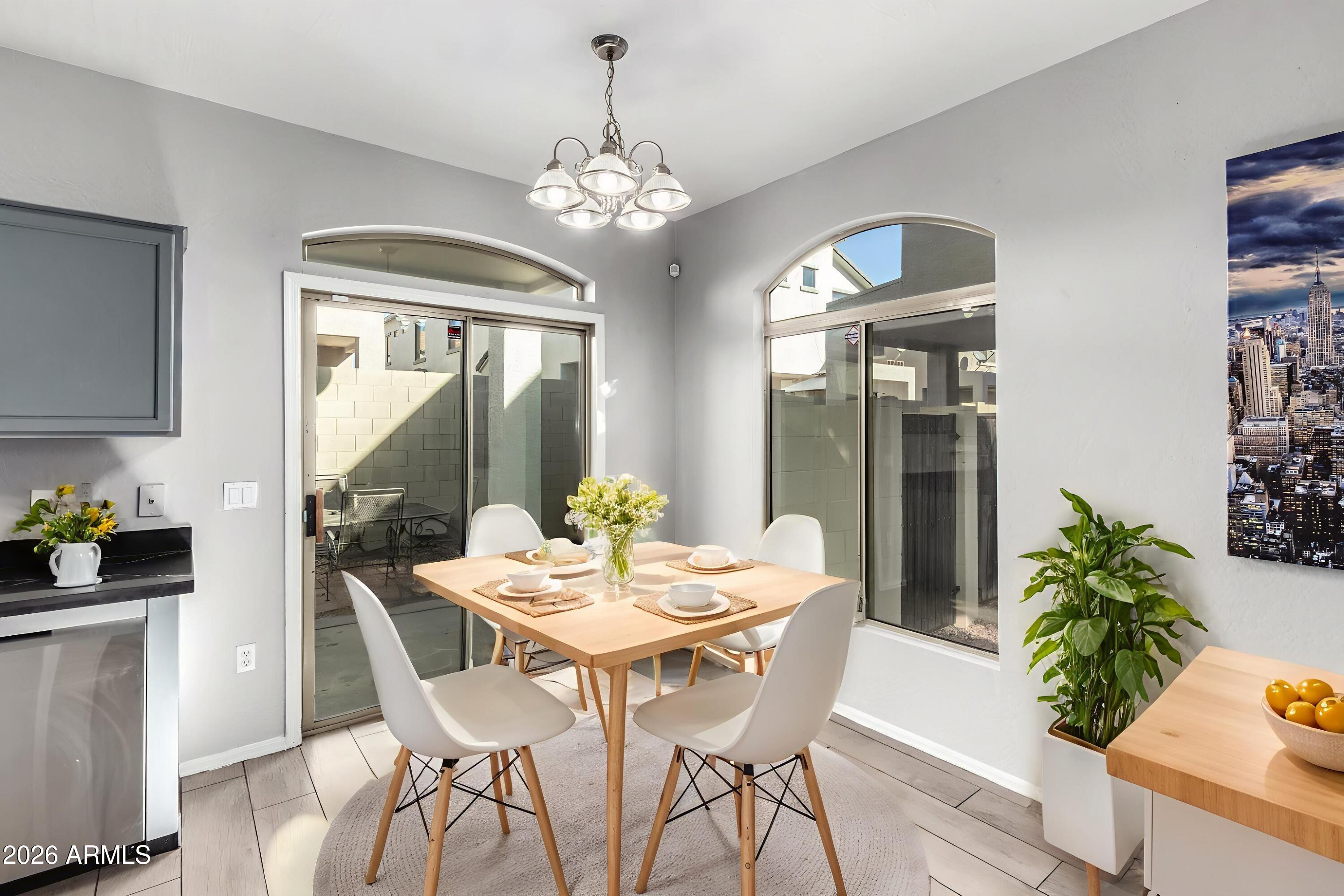 2150 East Bell Road, Unit 1075 Phoenix, AZ 85022 - Photo 9 of 45 a view of a dining room with furniture a chandelier and wooden floor
