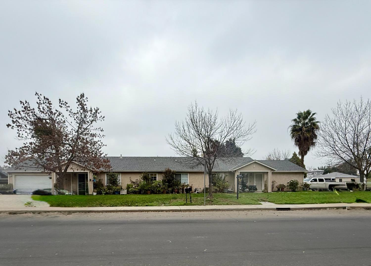 a front view of a house with a yard and potted plants