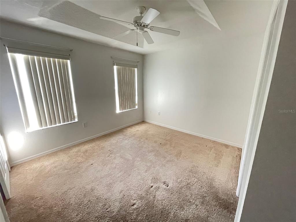 5168 Regatta Drive Kissimmee, FL 34746 - Photo 11 of 12 an empty room with windows and fan