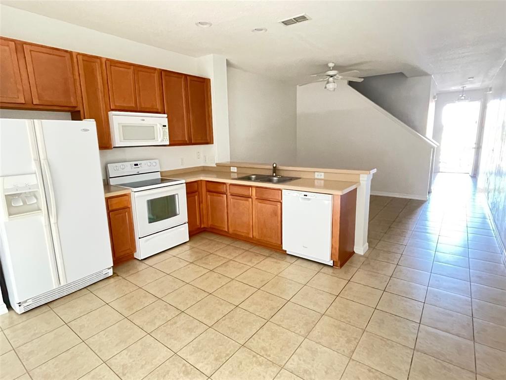 5168 Regatta Drive Kissimmee, FL 34746 - Photo 5 of 12 a kitchen with stainless steel appliances granite countertop a stove a sink and a refrigerator