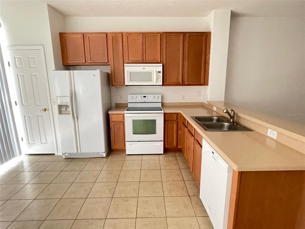 5168 Regatta Drive Kissimmee, FL 34746 - Photo 6 of 12 a kitchen with a sink stove and cabinets