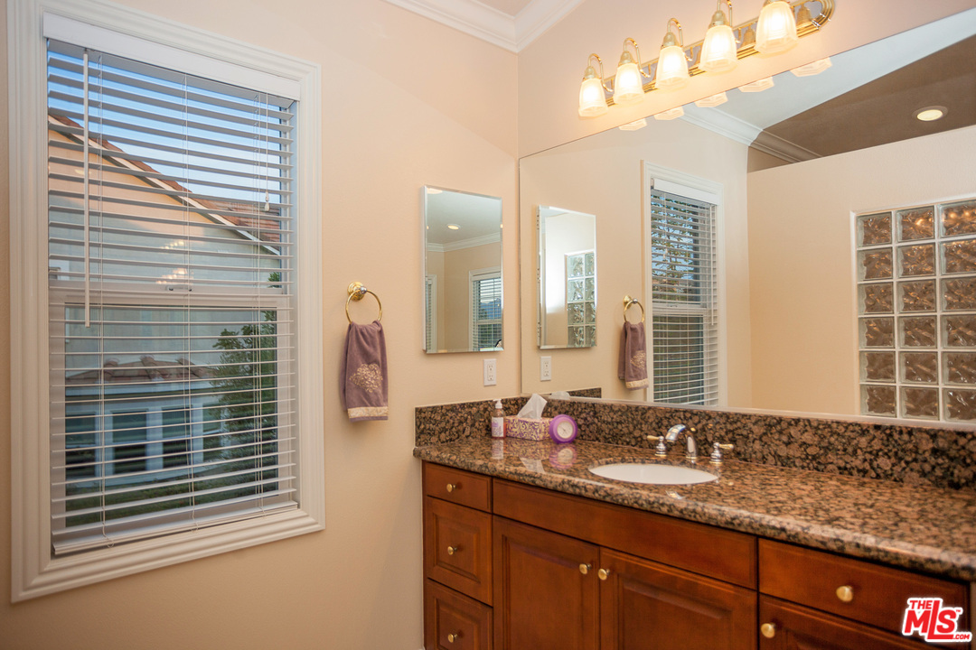 12090 Nelson Road Moorpark, CA 93021 - Photo 35 of 54 a bathroom with a granite countertop sink and a large mirror