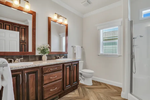 a bathroom with a granite countertop toilet a sink and a mirror