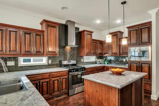 a kitchen with stainless steel appliances granite countertop a stove a sink and a refrigerator