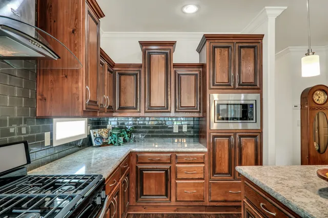 a kitchen with stainless steel appliances granite countertop a stove and a microwave