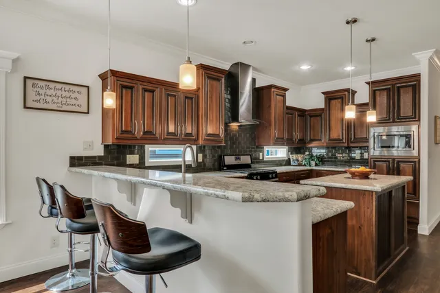 a kitchen with stainless steel appliances granite countertop a sink a stove and a refrigerator