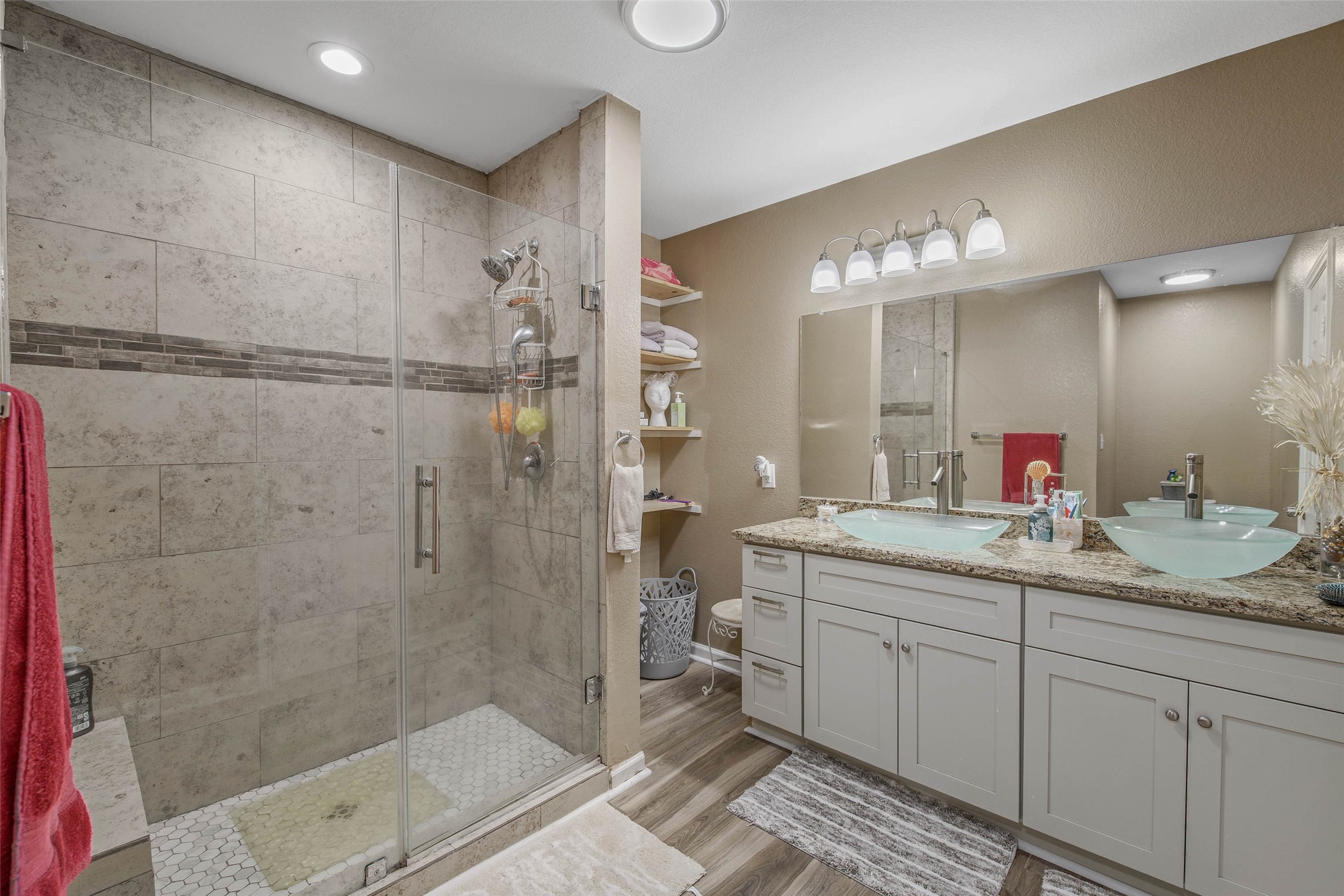 3876 Hummingbird Lane Bedias, TX 77831 - Photo 13 of 29 a bathroom with a granite countertop sink a mirror and a shower