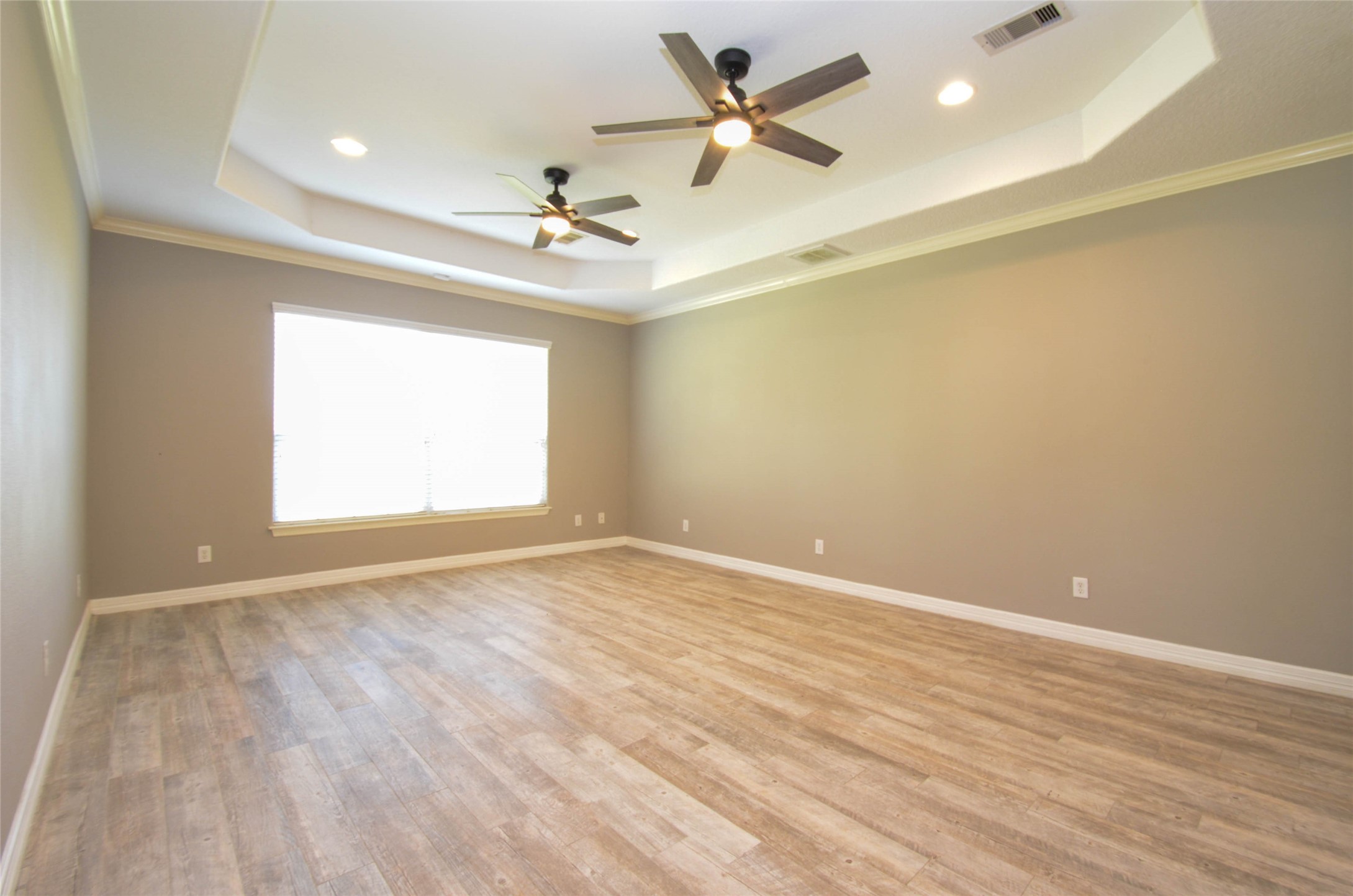 6125 Alleluia Trail Manvel, TX 77578 - Photo 11 of 25 an empty room with wooden floor ceiling fan and windows