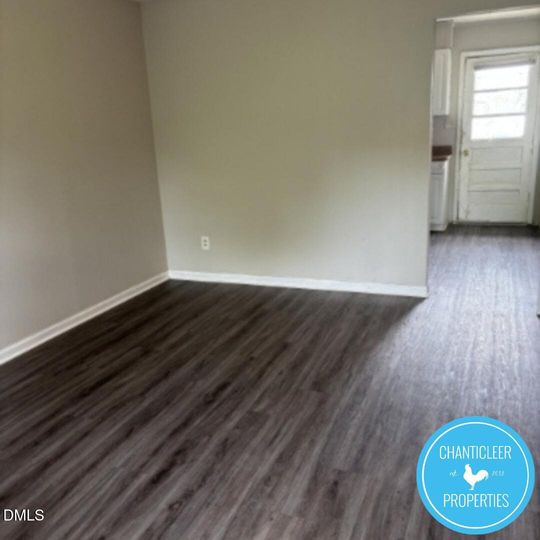 115 Florence Street, Unit 9 Graham, NC 27253 - Photo 4 of 14 a view of an empty room with a window and wooden floor