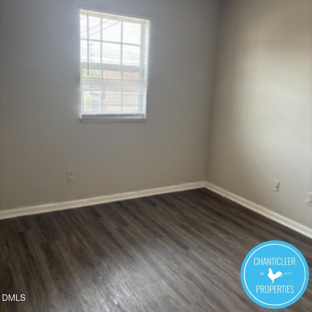 115 Florence Street, Unit 9 Graham, NC 27253 - Photo 8 of 14 an empty room with wooden floor and windows