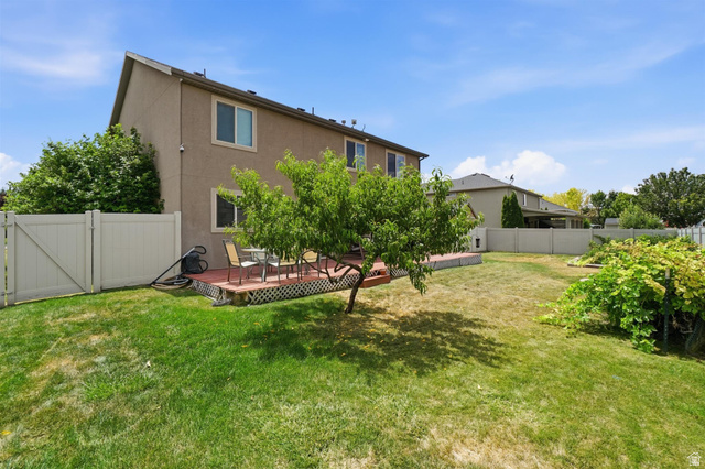 592 West 650 South Springville, UT 84663 - Photo 21 of 33 Expansive backyard featuring a manicured lawn, full privacy fencing, and a dedicated wood deck patio