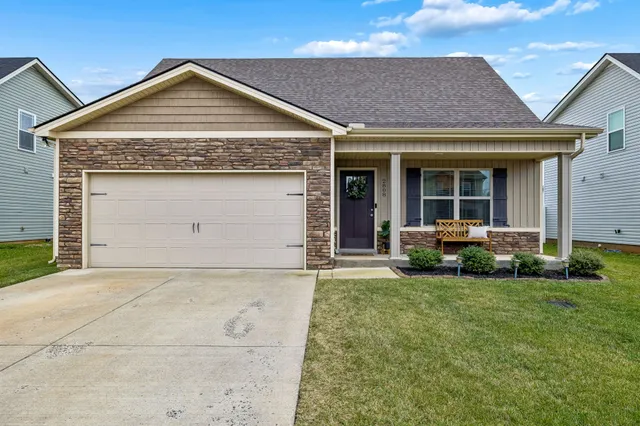 a front view of a house with a garden and plants