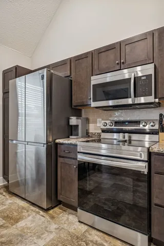 a kitchen with granite countertop a stainless steel appliances and cabinets
