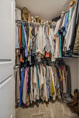 a view of walk in closet with clothes