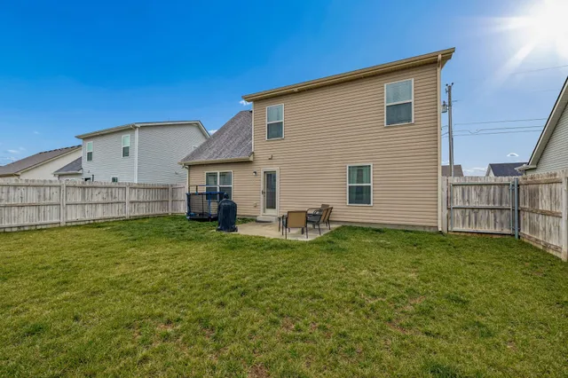 a view of backyard of house with wooden deck and seating space