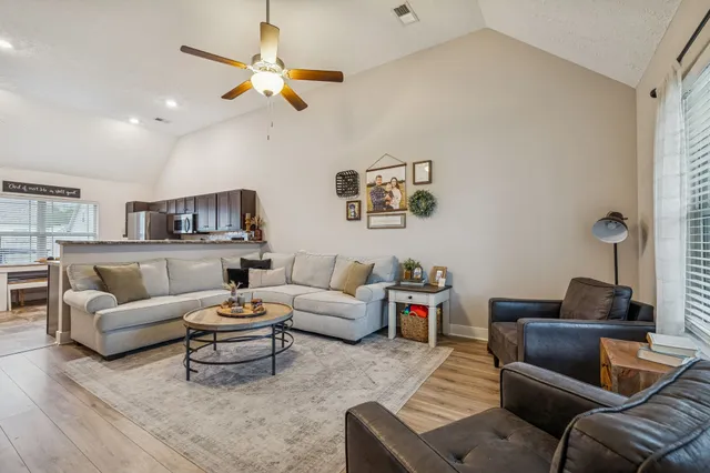 a living room with furniture and a ceiling fan