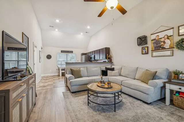 a living room with furniture kitchen view and a rug